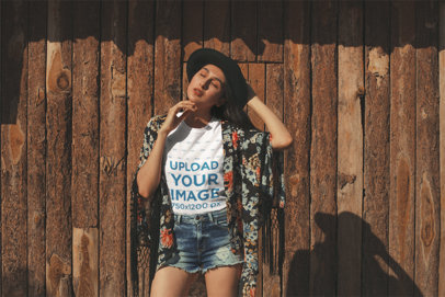 Mockup of a Woman Wearing a T-Shirt Against a Wooden Wall