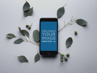 Space Gray iPhone 8 Mockup on a Gray Surface with Bay Laurel Leaves