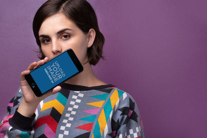 Mockup of a Young Woman Showing a Space Gray iPhone 8 Against a Violet Background 21834