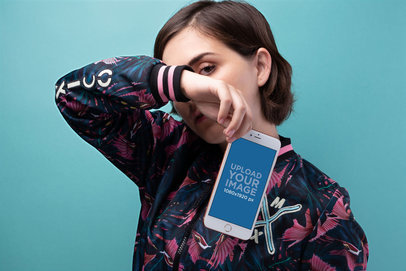 Gold iPhone 8 Plus Mockup of a Woman Covering her Face Against a Cyan Background