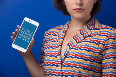 Gold iPhone 8 Mockup of a Young Woman in a Colorful Striped Shirt Against a Blue Background 21832