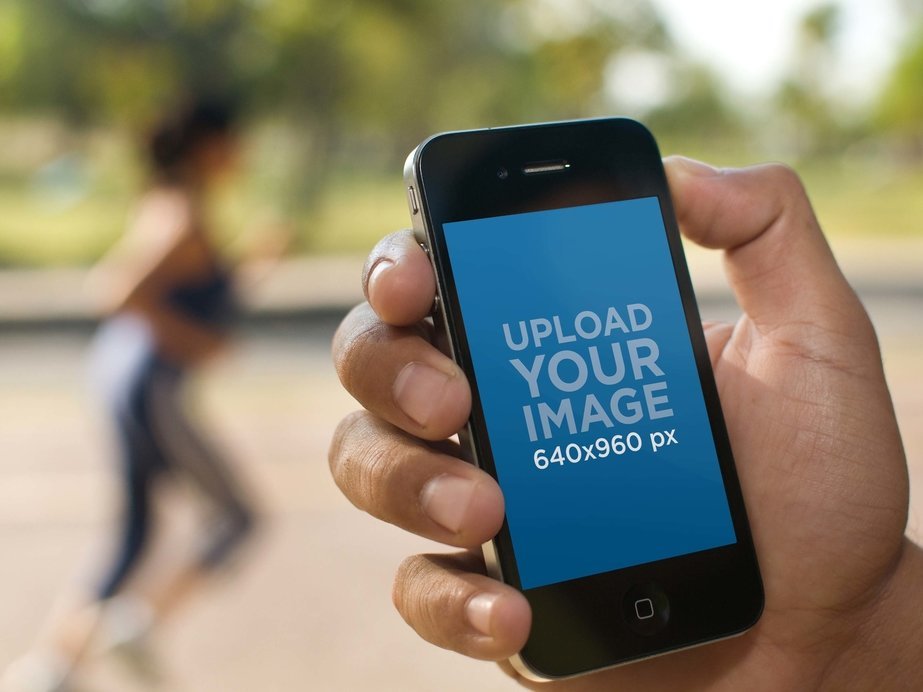 Mockup of a Man Holding an iPhone 4 at the Park