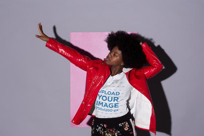 Tee Mockup Featuring a Cool Girl with an Afro Hairstyle Posing Against a Gray Background with a Pink Cardboard 21711
