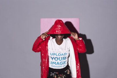 Mockup of a Woman Wearing a T-Shirt Covering Her Face With Her Hood