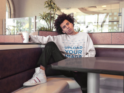 Sweatshirt Mockup of a Guy with Afro Hair Posing Inside a Restaurant Holding a Soda 18330