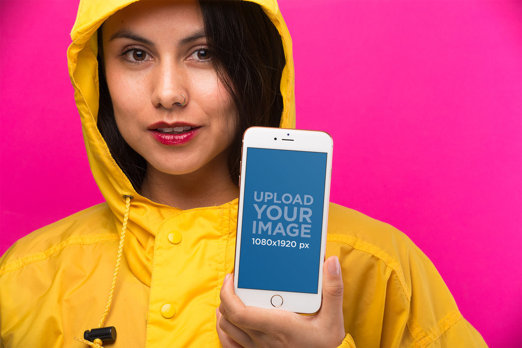 Mockup of an iPhone 8 Plus Held by a Woman Wearing a Bright Yellow Raincoat