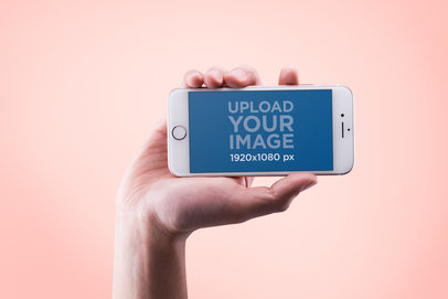 Mockup of a Hand Holding an iPhone in Landscape Position