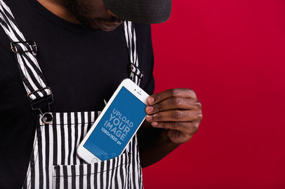 iPhone 8 Plus Mockup Featuring a Man Wearing a Black and White Striped Overall