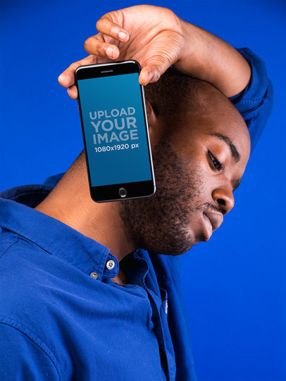 Mockup of a Man Holding a Space Gray iPhone 8 Against a Vivid Blue Background 22088