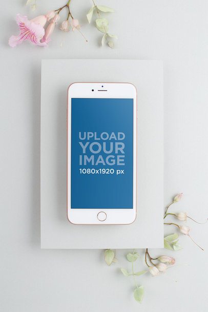 Mockup of an iPhone on a Matte White Cardboard Environment with Flowers 22136