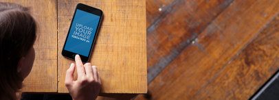 Mockup of a Woman Using an iPhone 6 at a Restaurant