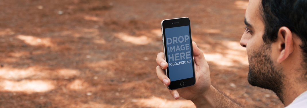 Mockup of a Bearded Man Using iPhone 6 Outdoors