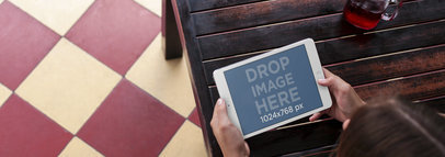 Tablet Mockup of a Woman Using an iPad Mini at a Restaurant