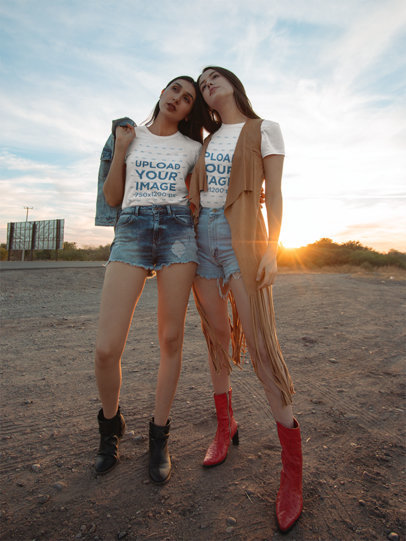 T-Shirt Mockup Featuring Two Women in a Bohemian Style Posing by a Dirt Road