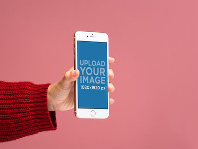 Mockup of a Gold iPhone 8 Plus in front of a Salmon Colored Background 22162