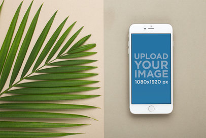 Silver iPhone 8 Plus Mockup Lying Next to Large Leaves
