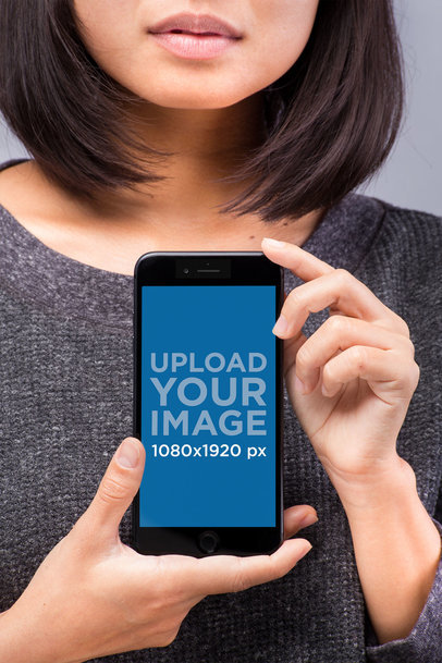 Mockup of a Space Gray iPhone 8 Held by a Woman Wearing a Gray Sweater
