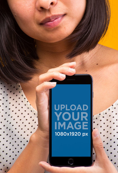 Mockup of a Woman in a Polka Dot Shirt Showing a Space Gray iPhone 8