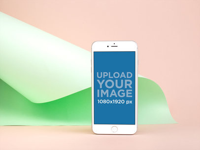 iPhone 8 Plus Mockup Standing Against a Light Green Folded Cardboard 22191