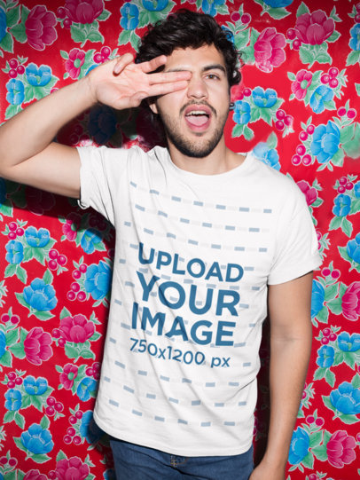 Mockup of a Man Wearing a T-Shirt Against a Red Printed Plastic Tablecloth 18762