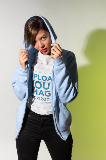 T-Shirt Mockup Featuring a Woman Wearing a Light Blue Zip-Up Hoodie