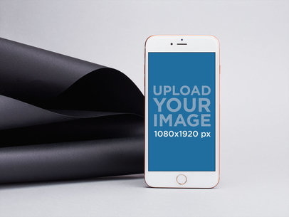 iPhone 8 Plus Mockup Leaning Over Black Spiraled Cardboard 22193