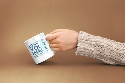 Mockup of a Female Hand Holding a Coffee Mug Against a Flat Color 22372