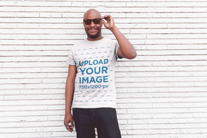 T-Shirt Mockup of a Smiling Middle-Aged Man Posing in Front of a White Wall