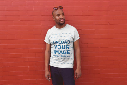 Tshirt Mockup of a Bald Man Posing Against a Red Wall
