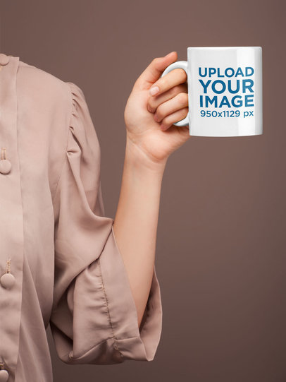 Coffee Mug Mockup Held In Front of a Tan Backdrop