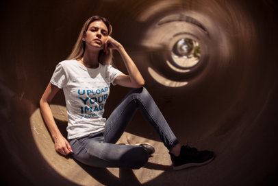 Mockup of a Thin Woman with T-Shirt and Jeans Sitting in a Tunnel