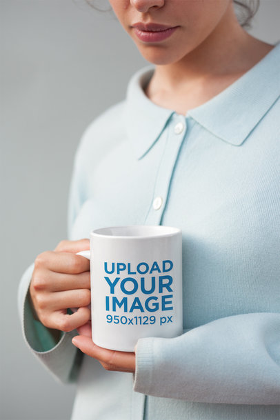 Mockup of a Coffee Mug Held by a Woman Wearing a Blue Sweater