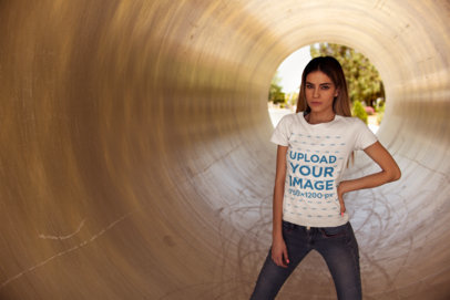 Round-Neck Tee Mockup Featuring a Woman in Jeans  Posing Inside a Circular Tunnel