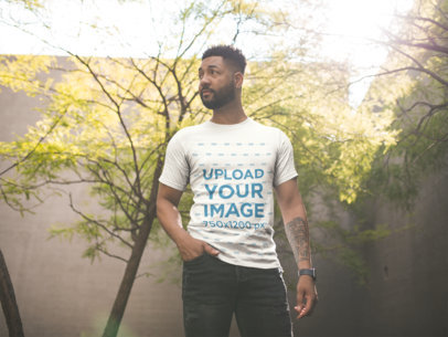 Mockup of a Man with a Tshirt and Black Jeans Against a Tree