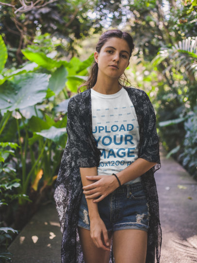 Mockup of a Woman Wearing a Round Neck Tee on a Trail with Plants