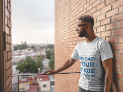 T Shirt Mockup Featuring a Handsome Man Standing in a Balcony
