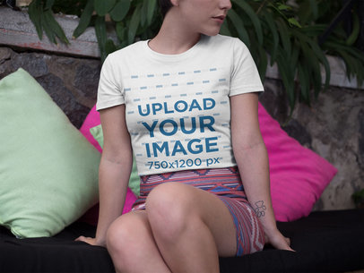 Mockup of a Woman Wearing a Round Neck Tshirt Against Pillows