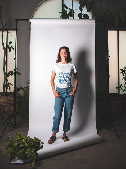 T-Shirt Mockup of a Woman Surrounded by Plants in a Studio Setting 