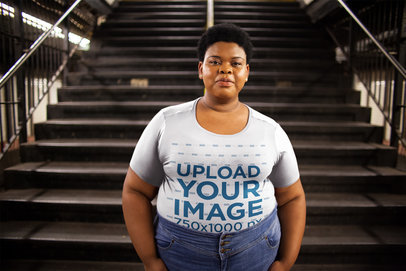Plus Size T-Shirt Mockup of a Woman in Front of an Industrial Staircase
