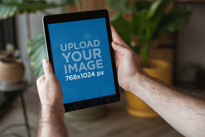 Mockup of an iPad Being Held in Portrait Position Indoors 22605