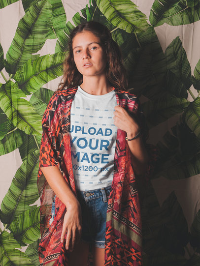 Round Neck T-Shirt Mockup Featuring a Woman Standing Against a Printed Curtain