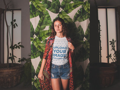 T-Shirt Mockup Featuring a Woman In Front of a Palm Leaf Curtain