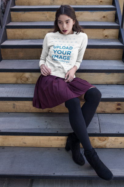 Mockup of a Woman Wearing a Sweatshirt and Sitting on a Staircase