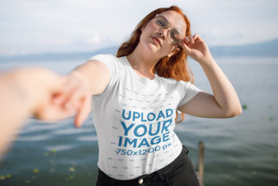 Camping T-Shirt Mockup Featuring a Woman on a Dock Holding Someone's Hand