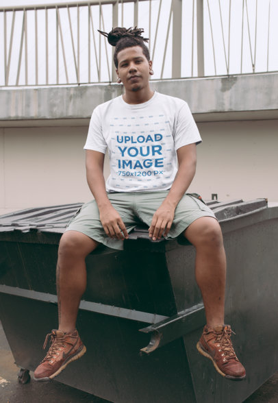 Roundneck Tee Mockup of a Man with a Loc Style Sitting on a Bin