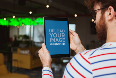 Mockup of a Redhead Man Holding an iPad at a Restaurant 22615