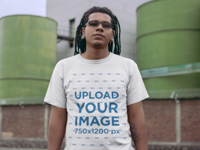 T-Shirt Mockup of a Serious Man With Locks In Front of an Industrial Site
