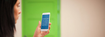 iPhone 6 Mockup Featuring a Brunette Woman Against a Green Backdrop a3041wide