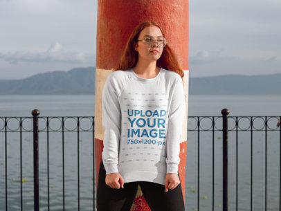 Mockup of a Hipster Woman Wearing a Sweatshirt and Leaning on a Pillar