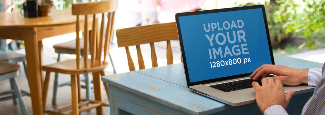 Laptop Mockup of a Businessman Using Macbook Pro at a Small Restaurant